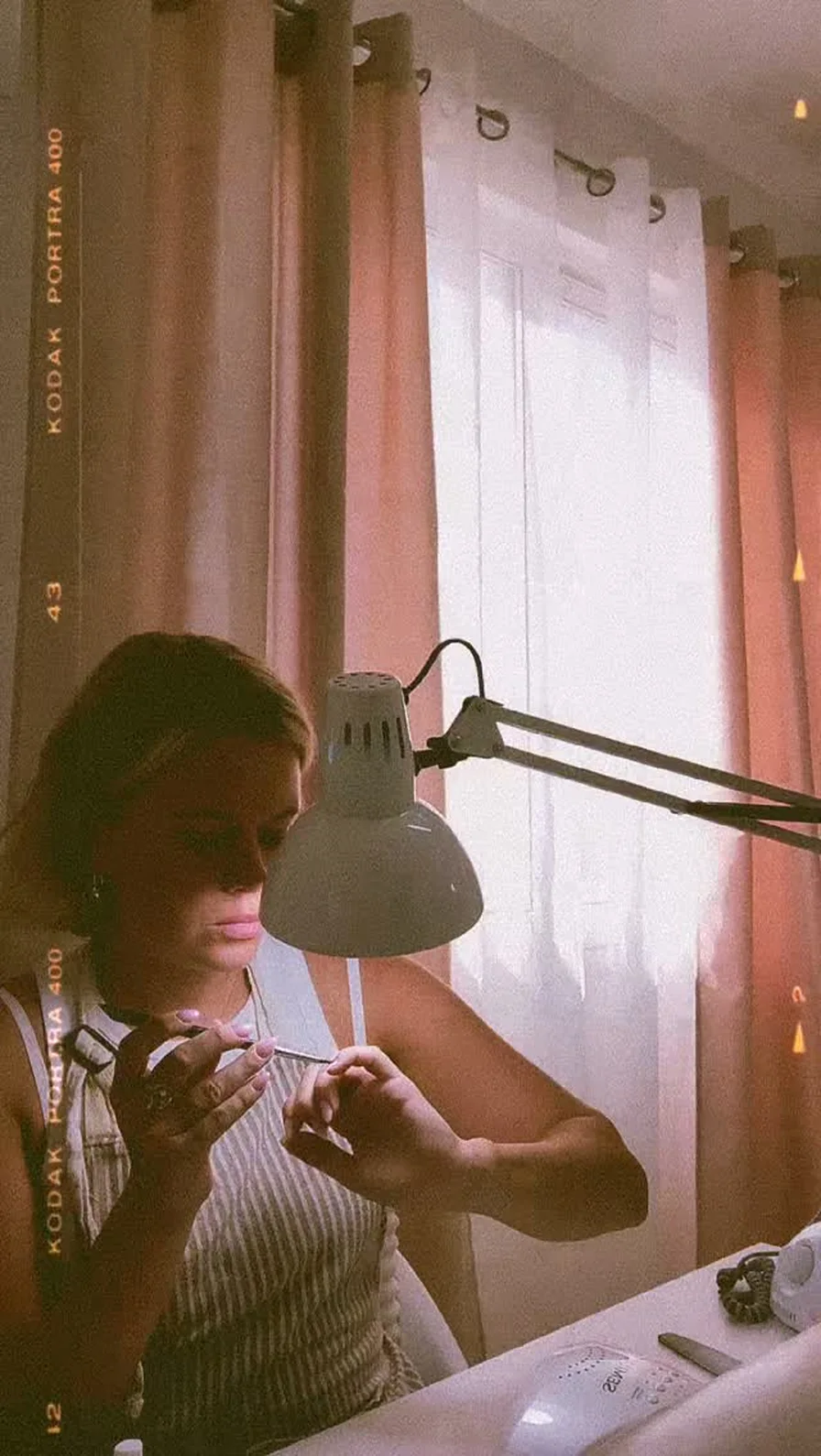 The nail tech at her desk under the lamp in the nail room